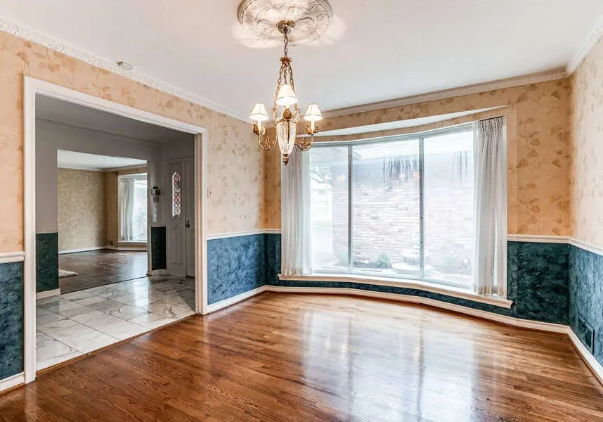Dining room with bay window, hardwood floors and navy painted wainscoting, an interior painting project by San Miguel Painting in Dallas, Texas