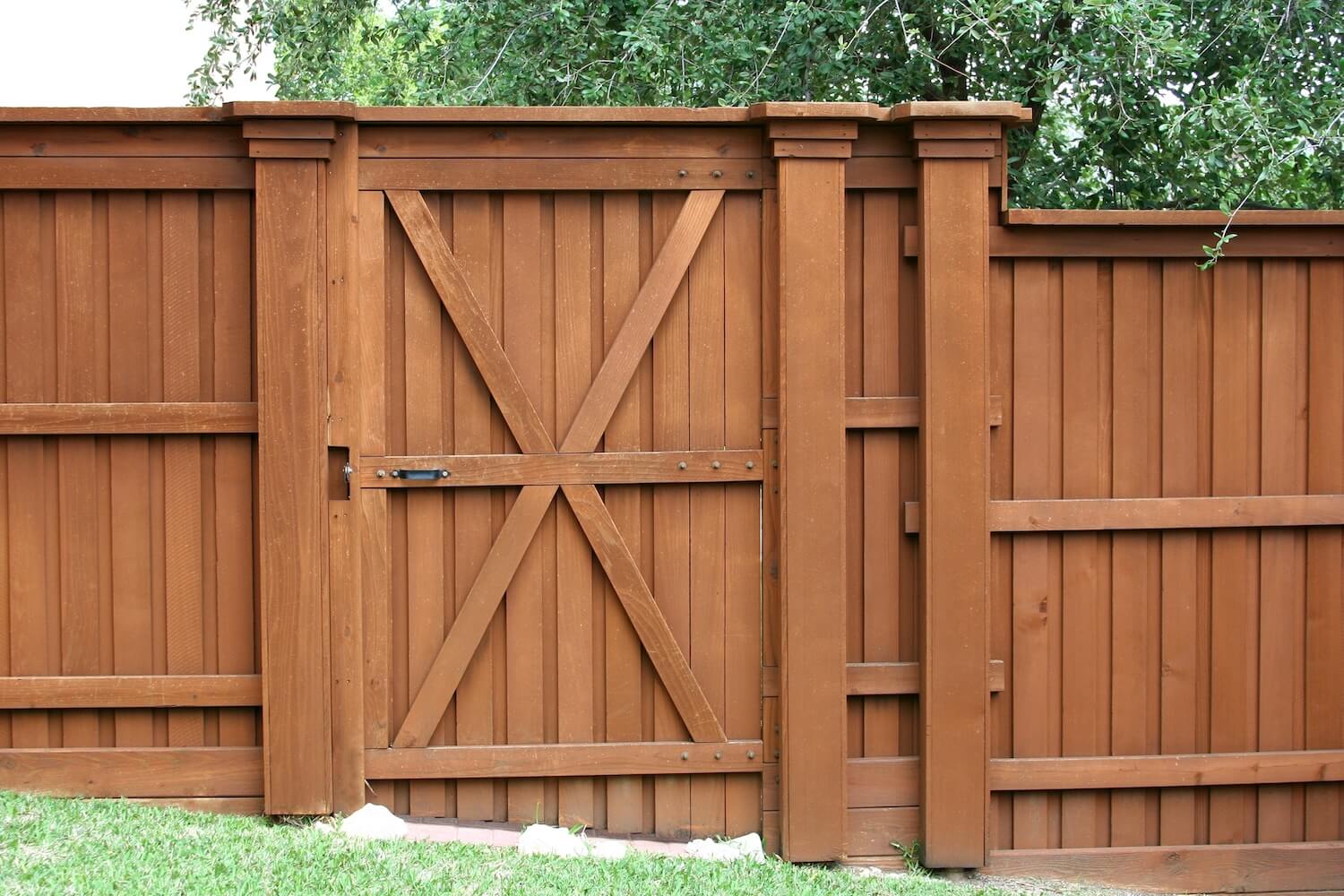 Stained wood privacy fence and gate with X brace design, fence staining services in Dallas, Texas