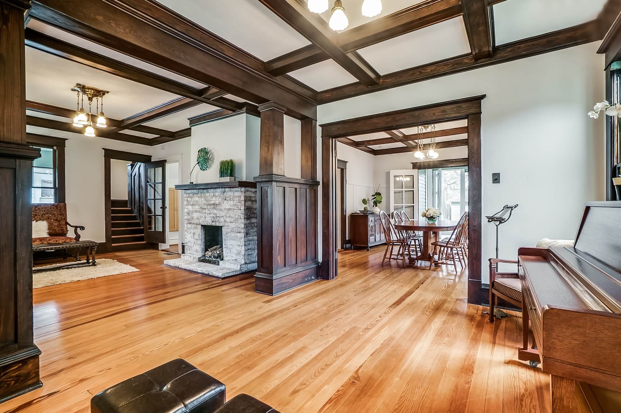 Craftsman home interior with white walls, dark wood beams and a painted brick fireplace, residential painting in Dallas, Texas