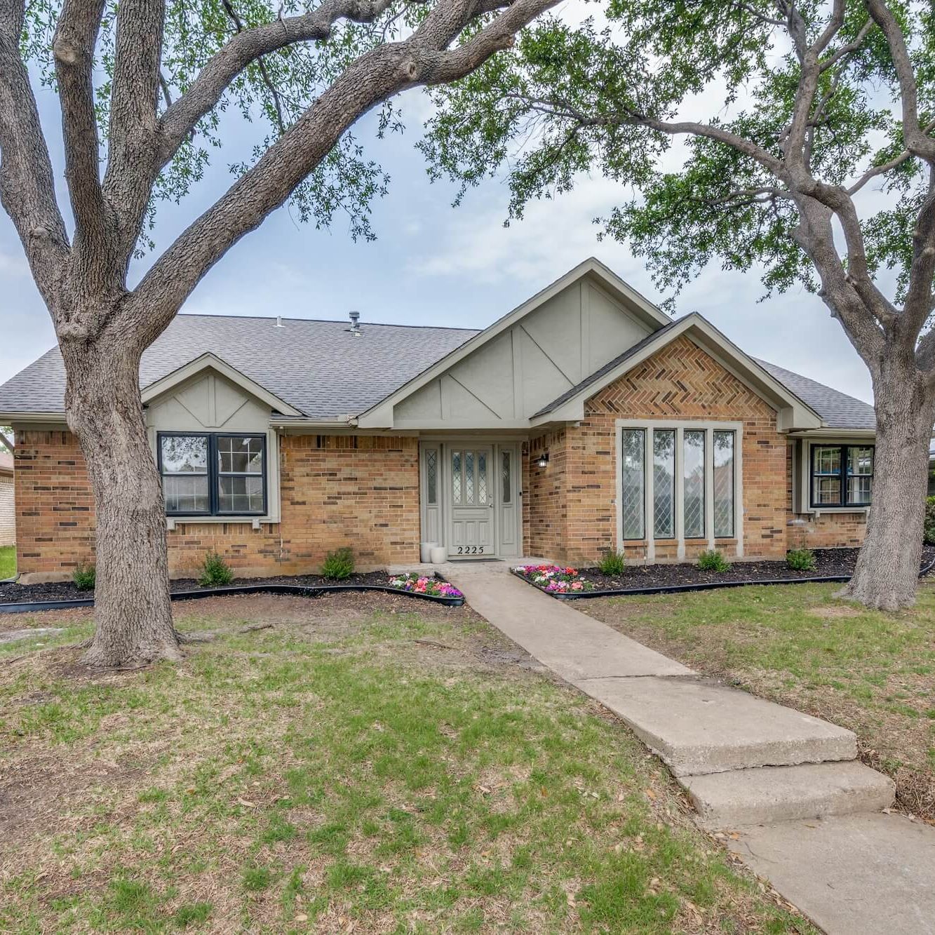Brick ranch home with freshly painted gray siding gables and trim, exterior painting by San Miguel Painting in Carrollton, Texas