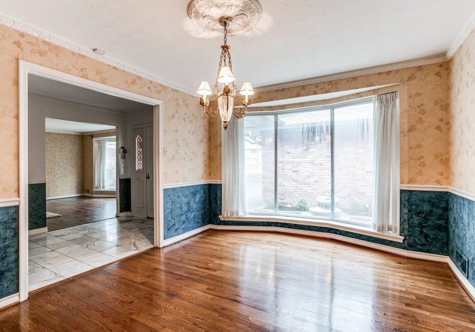 Dining room with bay window, hardwood floors and navy painted wainscoting, an interior painting project by San Miguel Painting in Dallas, Texas
